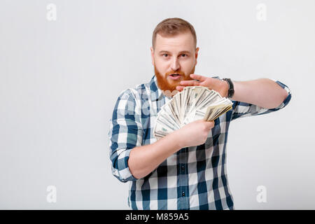 Junge schöne lächelnden Mann mit Bart in Plaid Shirt Holding eine Menge 100-Dollar-Scheine. Kopieren Sie Platz Stockfoto