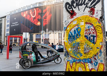 Ein Fahrrad Taxi Fahrer wartet für Kunden am Potsdamer Platz in der Nähe eines von Stück der Berliner Mauer Am 15. April 2017 in Berlin, Deutschland Stockfoto