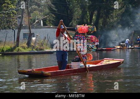 Ein Mann mit Souvenirs auf einer trajinera in Xochimilco, Mexico City Stockfoto