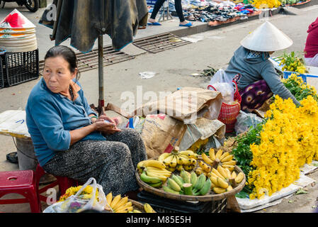 Eine Frau verkauft Bananen auf der Straße an einer im Markt in Hoi An, Vietnam Stockfoto