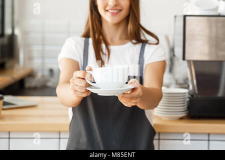 Kaffee Business Concept-kaukasischen Frauen Kaffee beim Stehen in der Coffee Shop. Fokus auf weibliche Hände eine Tasse Kaffee. Stockfoto