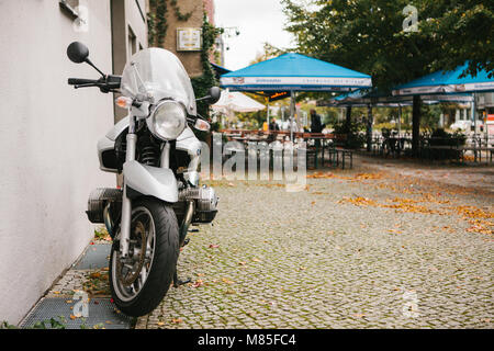 Ein modernes BMW Motorrad auf der Straße geparkt Neben einem Street Cafe. Einen praktischen und schnellen Transportmittel für eine große Stadt Stockfoto