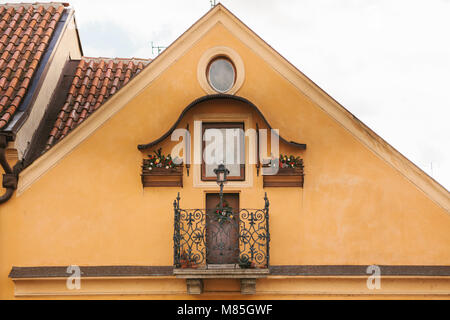 Fassade des Hauses in Gelb lackiert und dekoriert mit Weihnachtsschmuck - Weihnachten - Baum Kränze und Bild der Jungfrau Maria mit t Stockfoto