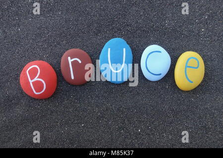 Buchungstext geschnitzt und auf einen Stein mit schwarzen vulkanischen Sand Hintergrund farbig Stockfoto