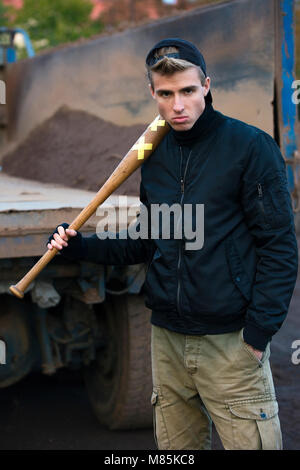 Aggressive blondes Haar hooligan mit dem Baseballschläger in der Hand auf der Suche nach einem Ziel Stockfoto