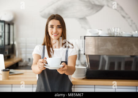 Kaffee Business Concept-kaukasischen Frauen Kaffee beim Stehen in der Coffee Shop. Fokus auf weibliche Hände eine Tasse Kaffee. Stockfoto