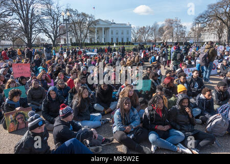 Washington, DC, USA. 14. März, 2018. Studenten aus dem Bereich High School Sitzen mit dem Rücken zum Weißen Haus während der Nationalen Schule Streik, Protest der Regierung Untätigkeit auf Gewehr Kontrolle, während die Solidarität für die 17 Studenten in Marjory Stoneman Douglas High School in Parkland, Florida ermordet. Die 17-minütige Protest wurde durch eine im März auf dem US Capitol gefolgt. Bob Korn/Alamy leben Nachrichten Stockfoto