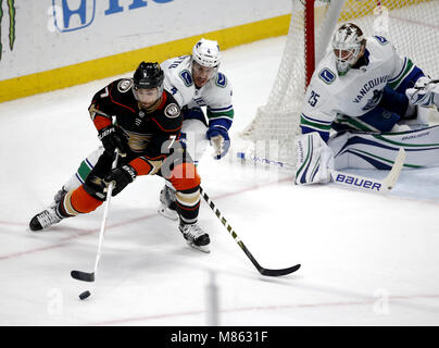 Los Angeles, Kalifornien, USA. 14 Mär, 2018. Vancouver Canucks' goalie Jakob Markstrom (25) schützen Sie die Net als Vancouver Canucks' Verteidiger Michael Del Zotto (4) Mias mit Anaheim Ducks, Andrew Cogliano (7) Während einer 2017-2018 NHL Hockey Spiel in Anaheim, Kalifornien, am 14. März 2018. Die Ducks gewann 3-0. Credit: Ringo Chiu/ZUMA Draht/Alamy leben Nachrichten Stockfoto