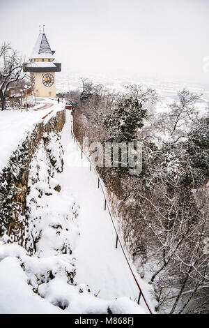 Pfad zu schneebedeckten Uhrturm Uhrturm Wahrzeichen der Stadt Graz auf Hill Schlossberg im Winter Stockfoto