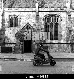 Mann mit Helm reiten auf einem Motorroller fahren vorbei an einer Kirche, die in eine Bar und ein Nachtclub in York, England umgewandelt wurde, UK zeigen Vergangenheit Stockfoto