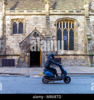 Mann mit Helm reiten auf einem Motorroller fahren vorbei an einer Kirche, die in eine Bar und ein Nachtclub in York, England umgewandelt wurde, UK zeigen Vergangenheit Stockfoto