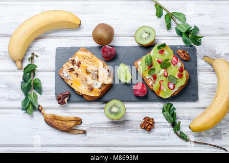 Gesundes Frühstück mit Toast. Süße Brötchen mit Frischkäse und frischen Beeren und Obst auf weißem Hintergrund. Gesunde Ernährung und Diät Konzept. Zu Stockfoto