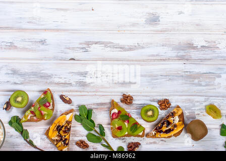 Gesundes Frühstück mit Toast. Süße Brötchen mit Frischkäse und frischen Beeren und Obst auf weißem Hintergrund. Gesunde Ernährung und Diät Konzept. Zu Stockfoto