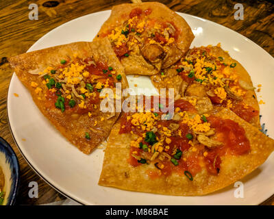 Vietnamesische Gürtel Kuchen essen, bestehend aus Reis, Pfannkuchen mit Gemüse und Chili Sauce. Stockfoto