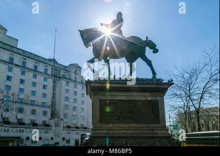 Silhouette der Bronzestatue von Ritter reiten ein Pferd mit Sun Flare, Leeds City Square, von Queens Hotel. Stockfoto