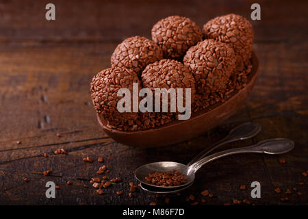 Ei Schokolade mit Befüllung von brigadeiro für Ostern auf Holz- Hintergrund. Selektiver Fokus Stockfoto