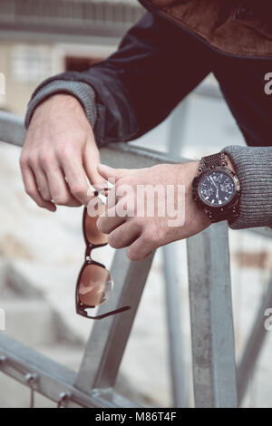 Mann hält in der Hand Sonnenbrille, Luxusuhr sichtbar auf seine Hand Stockfoto