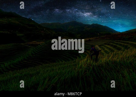 Landschaft mit der Milchstraße. Nachthimmel mit Sternen und Silhouette Fotografen Foto auf Reisfelder in Mu Cang Chai Reihenhaus. Lange exposu Stockfoto