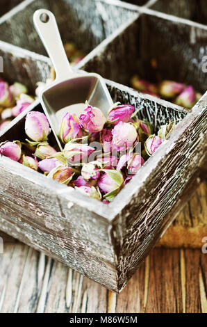 Kleine chemische Knospen der Rosen, Tee, Karkade, in hölzernen Schüsseln auf Holz Tisch, selektiver Fokus Stockfoto