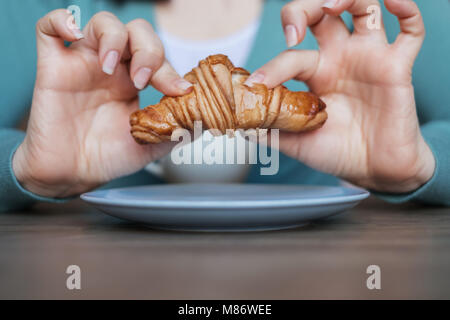 Frau Hände halten ein Croissant Stockfoto