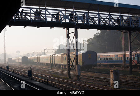 Blick auf den Bahnhof, Tracks und geparkte Zug in Indien. Die Menschen sind über die Kreuzung Brücke über Züge Plattformen austauschen. Es ist Januar mornin Stockfoto