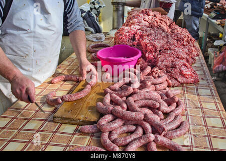 Der Metzger macht hausgemachte Wurst in der Open Air in traditioneller Weise. Stockfoto