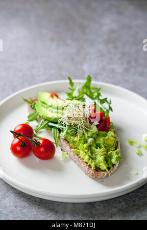 Roggen Toast mit Avocado, Tomaten und Alfalfa Sprossen Stockfoto