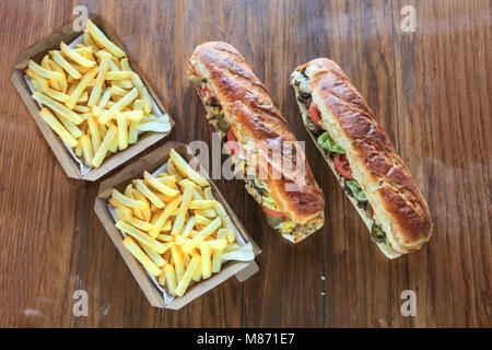 Extra große mächtige Sandwiches mit Box der Kartoffel Pommes Frites essen für Zwei Stockfoto