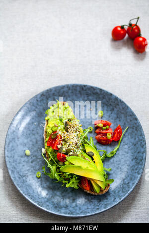 Roggen Toast mit Avocado, Tomaten und Alfalfa Sprossen Stockfoto