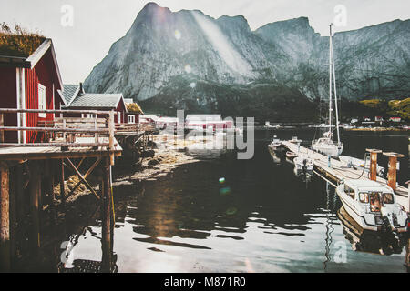 Reine Dorf in Norwegen traditionelle Rorbu rote Häuser am Meer und die felsige Berge reisen Landschaft der Lofoten Inseln Stockfoto