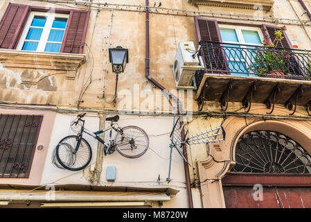 Fahrrad hängen neben einem Fernseher Antenne an der Wand der Fassade eines alten Gebäudes in der Altstadt von Palermo auf Sizilien, Italien Stockfoto