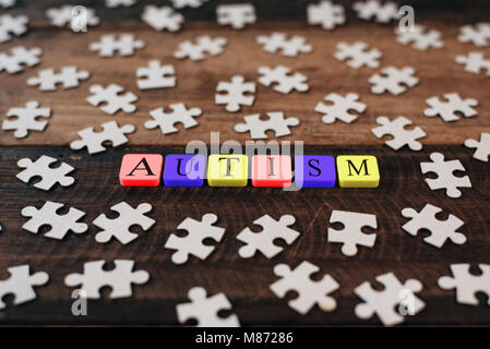 Bunte Puzzle und Alphabet Fliesen mit Autismus Wort. Autismus Konzept Stockfoto