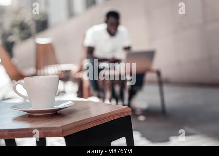 Afrikanische amerikanische Mann bei der Arbeit am Notebook im lokalen Cafe Stockfoto