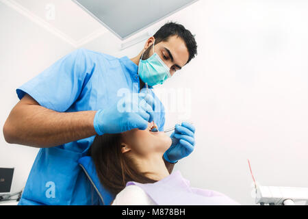 Zahnarzt untersucht die Zähne des Patienten Stockfoto