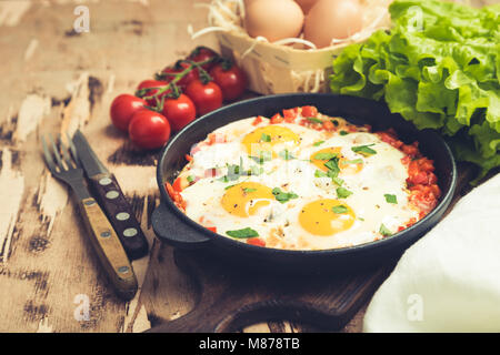 Lecker und gesund Shakshuka in der Pfanne. Spiegeleier mit Tomaten, Paprika, Gemüse und Kräuter. Im Nahen und Mittleren Osten traditionelles Gericht Stockfoto