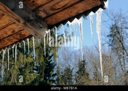 Eiszapfen auf einem Dach eines hölzernen im Frühjahr abgeworfen Stockfoto