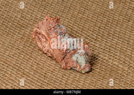 Nahaufnahme einer nativen Kupfer nugget mit Crystal Verunreinigungen. Studio Makro. Sackleinen Hintergrund. Probe wird aus der Upper Michigan Keweenaw Peninsula. Stockfoto