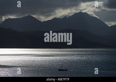 Segeln home. Ein Fischerboot auf dem Heimweg durch die Narrows von raasay mit den Cuillin Hills auf Skye als Tuch. Stockfoto