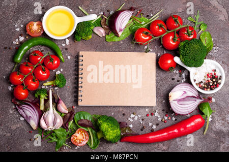 Frisches Bio-Gemüse, Kräutern und Gewürzen. Gemischter Salat, Tomaten, Chili, Knoblauch auf Stein Hintergrund. Gesunde Ernährung, gesunde Lebensweise und Ernährung Konzept. Stockfoto