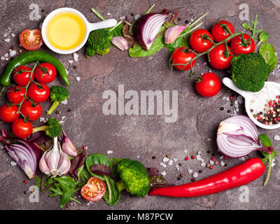 Frisches Bio-Gemüse, Kräutern und Gewürzen. Gemischter Salat, Tomaten, Chili, Knoblauch auf Stein Hintergrund. Gesunde Ernährung, gesunde Lebensweise und Ernährung anhand von quantitativen Simulatio Stockfoto