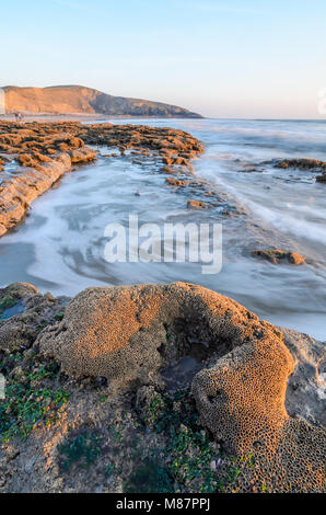 Sonnenuntergang über den felsigen Küstenlinie von Dunraven Bay, Southerdown in South Wales Stockfoto