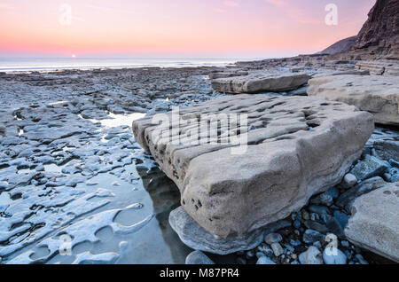 Sonnenuntergang über den felsigen Küstenlinie von Dunraven Bay, Southerdown in South Wales Stockfoto