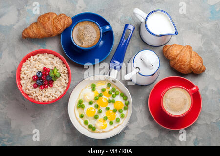 Das traditionelle Frühstück mit Eiern, Müsli, Croissants und Kaffee. Ansicht von oben Stockfoto