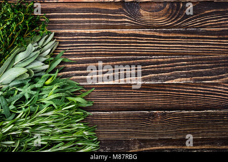 Frische Kräuter und Gewürze aus dem Garten auf alten Holztisch. Gesunde Ernährung und gesundes Kochen Konzept. Ansicht von oben Stockfoto