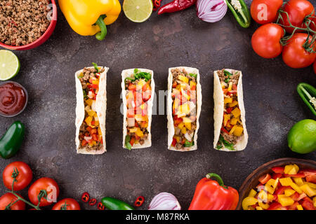 Mexikanische Tacos mit Gemüse und Fleisch. Zutat für das Kochen Tacos al Pastor auf konkreten Hintergrund. Ansicht von oben Stockfoto