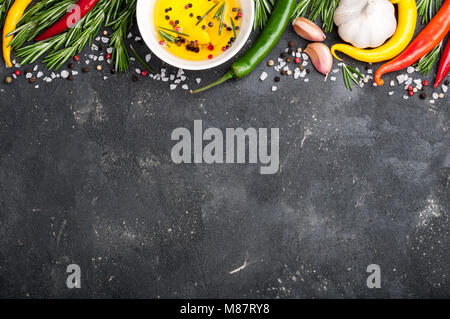 Kräuter und Gewürze. Rosmarin, Chili, Knoblauch, Olivenöl, Salz und Pfeffer auf dunklen Tabelle Ansicht von oben Stockfoto