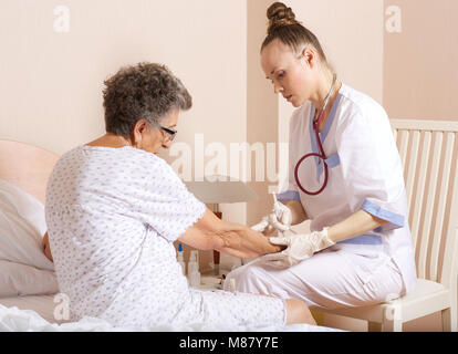 Medical Assistant überprüft die Adern der älteren Frau, die für Transfusionen Stockfoto