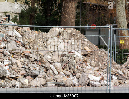 Ein Haufen von Schutt auf einer Baustelle hinter einer unscharfen Zaun Stockfoto