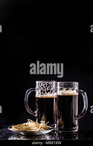 Becher mit Bier auf Tisch Stockfoto