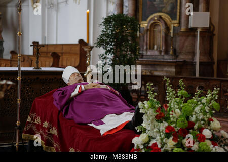 Mainz, Deutschland. 15. März 2018. Der Körper Kardinal Karl Lehmann liegt vor dem Altar auf einem Katafalk, tragen seiner Päpstlichen Gewänder, die aus einem violett Kasel, seine Mitra, Brustkreuz und seine kirchlichen Ring. Seine crosier steht neben ihm. Der Körper von Kardinal Karl Lehmann liegt in der Ruhe in der Kirche St. Augustin in Mainz, so die Menschen Datei an ihm vorbei und Ihre letzten Respekt zu zahlen. Kardinal Karl Lehmann war der Bischof der Römisch-katholischen Diözese Mainz für 33 Jahre bis zu seiner Pensionierung im Jahr 2016. Quelle: Michael Debets/Alamy leben Nachrichten Stockfoto